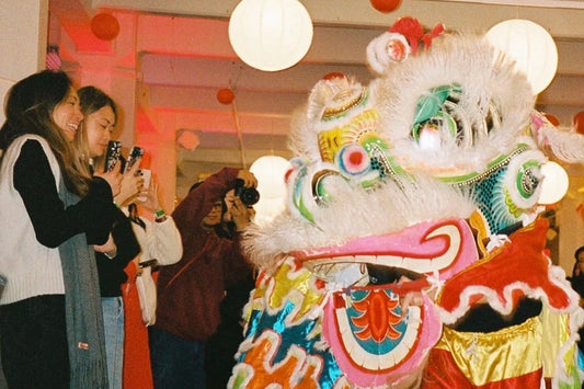 Lion dance and crowd at a Homecoming Matcha Lunar New Year pop-up in Denver