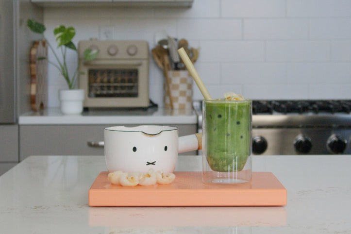 Iced matcha latte in a glass on a kitchen counter, made with Homecoming Matcha Uji Blend