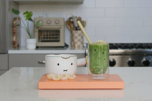 Iced matcha latte in a glass on a kitchen counter, made with Homecoming Matcha Uji Blend
