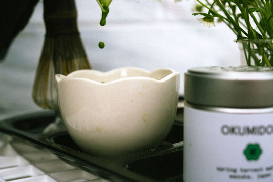 Whisking matcha in a bowl with a bamboo chasen, frothy green usucha